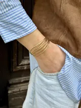 Juego de brazaletes dorados finos, de metal.