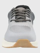 Zapatillas grises de tejido de punto con cordones, suela blanca y detalles en marrón.
