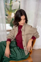 Campera de jean color beige con bordados florales en tonos rosa, verde y amarillo.