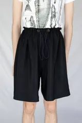 Bermuda holgada negra con cintura elastizada y hebillas de ajuste.