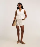 Short de mujer de cintura alta, confeccionado en sarga de algodón con rayas verticales punteadas. Presenta cintura sastre con trabillas y cierre tradicional.