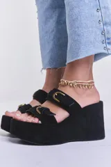 Sandalias negras de plataforma con dos tiras anchas de gamuza y hebillas doradas.