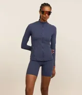 Campera deportiva negra confeccionada en poliamida y elastano, con cuello alto, cierre delantero por cremallera y bolsillos laterales.