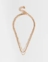 Collar corto dorado de tres capas con diferentes tipos de cadenas de metal.