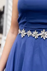 Vestido largo de fiesta color azul francia, con apliques de flores en la cintura y capa incluida.