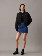 Campera bomber acolchada negra Calvin Klein, con logo bordado en el pecho y el puño. Confeccionada con poliéster reciclado, cuello, puños y bajo de canalé, cierre de cremallera, bolsillos con botón de presión en la cintura y forro ligeramente acolchado.