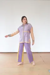 Camisa lila con mangas color beige, de silueta relajada confeccionada en paño de lana suave. Tiene canesú amplio, bolsillo delantero y aberturas laterales que aportan movimiento.