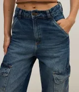 Pantalón wide leg de jeans con trabillas en la cintura, cierre por botón y cremallera, y bolsillos cargo.