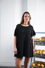 Vestido corto negro con patrón calado cuadrado, cuello redondo y mangas cortas con terminaciones a contratono en blanco.