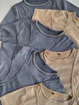 Remera gris de corte crop con cuello redondo y detalle de costuras a la vista.