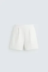 Bermuda color blanco hueso, de corte relaxed fit, confeccionada en tejido interlock de algodón con elasticidad. Presenta cintura elástica ajustable con cordón interior, bolsillos laterales y bolsillo trasero de plastrón.