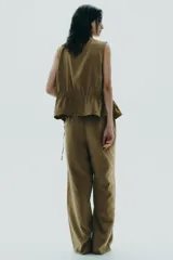 Pantalón palazzo color verde oliva de tejido fluido, tiro medio, cintura elástica ajustable con cordones y bolsillos laterales.