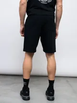 Bermuda deportiva negra de felpa con logo de Umbro bordado en rojo en la pierna derecha.