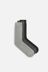Pack de tres pares de calcetines de algodón acanalados, en tonos gris oscuro, gris medio y gris claro.