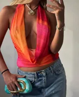 Minivestido de microtul rosado con estampado difuminado en tonos naranja y fucsia. Escote halter profundo y espalda descubierta.