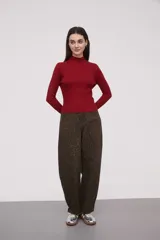 Polera de punto negro con cuello alto y manga larga, con diseño acanalado y ajuste ceñido.