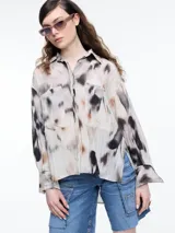 Camisa de manga larga confeccionada en viscosa crinkled con estampa de manchas. De silueta amplia y fluida, con bolsillos frontales grandes, tajos laterales y largo extendido en la espalda.