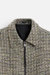 Sobrecamisa de tweed multicolor con cuello solapa, cierre frontal con cremallera, bolsillos laterales y puños abotonados.