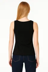 Musculosa negra sin mangas de poliéster, corte holgado y cuello profundo.