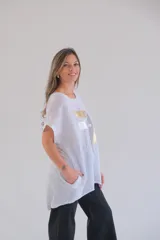 Blusa blanca de lino con estampado abstracto en dorado y plateado, de corte holgado y mangas cortas.