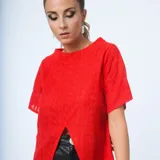 Remera roja de tejido texturizado, con cuello mao y mangas cortas. Presenta un corte en forma de V en el ruedo delantero.