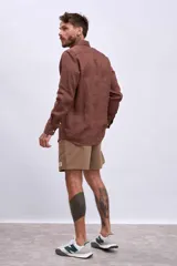 Camisa de lino color crudo, de corte recto, con cuello clásico y mangas largas.