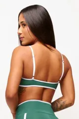 Top deportivo verde con detalles en blanco, logo minimalista y tirantes ajustables. Fabricado en poliamida y elastano con protección UV50+.