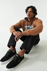 Canguro color crema con capucha y cordones negros, estampado frontal con la imagen de la creación de Adán y la palabra "Renaissance". Tiene bolsillos laterales y logo en grifa de goma.