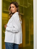 Sobrecamisa blanca de lino y rayón, marca Dash. Tiene cuello solapa, abertura central con botones, bolsillos delanteros y jareta interna de ajuste en la cintura.