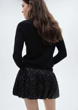 Minifalda negra con lentejuelas, cintura elástica y corte evasé.