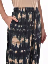 Pantalón babucha con estampado abstracto en tonos azul, beige y verde.