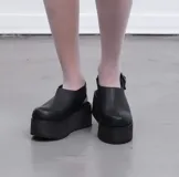 Suecos de cuero con estampado de vaca en blanco y negro, con plataforma de goma negra.