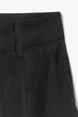 Pantalón negro de tiro alto con cintura con trabillas, bolsillos laterales y de vivo en espalda, pernera recta y cierre frontal con cremallera y botón. Confeccionado en hilatura con modal.