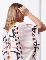 Kimono tejido con estampado abstracto en tonos beige, blanco y negro. Tiene mangas amplias estilo japonés y terminación de ruedo con borlas.
