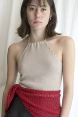 Top halter tejido en color beige, con tiras finas que se atan al cuello y espalda descubierta.