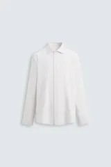 Camisa de vestir de hombre, de corte regular, color blanco con finas rayas verticales grises, cuello italiano abierto, manga larga con puños abotonados y cierre frontal con botones.