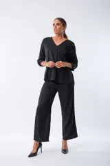 Pantalón palazo negro con estampado animal print, cintura elastizada con lazo y corte amplio.