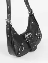 Cartera de hombro de cuero vegano color marrón con acabado texturizado. Presenta un diseño estilo hobo con hebilla frontal decorativa, herrajes metálicos plateados, argollas laterales y correa ajustable.