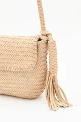 Cartera bandolera negra de cuero vacuno trenzado, con acceso superior con cierre metálico, interior forrado con bolsillos y correa de hombro trenzada.