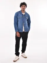 Campera de jean azul con cuello clásico, cierre frontal con botones metálicos, bolsillos con solapa abotonada en el pecho y bolsillos laterales.