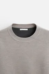 Sweater negro de punto con cuello redondo y mangas largas.