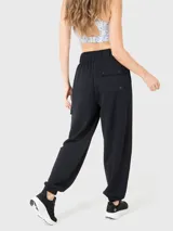 Pantalón de buzo negro de tela suave, con cintura elástica, bolsillos laterales y traseros, y elástico en los tobillos.