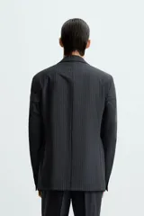 Blazer regular fit de lana con raya diplomática, cuello con solapas de muesca, manga larga con puño abotonado, bolsillos de vivo en pecho y de solapa en cadera, bajo con aberturas en espalda y cierre frontal de botonadura.