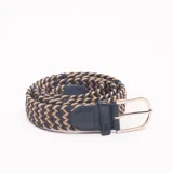 Cinturón trenzado elástico en tonos beige y azul marino, con apliques de cuero azul y hebilla metálica plateada.