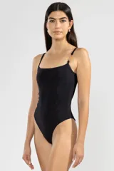 Traje de baño enterizo negro con breteles finos y detalle de cadena dorada en uno de los hombros.