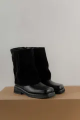 Bota corta de cuero negro, con caña baja de gamuza y suela track.