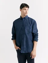 Camisa azul oscuro con estampado de motas blancas, de manga larga y corte clásico.
