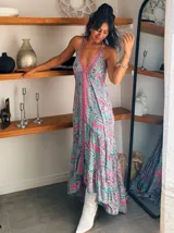 Vestido largo con estampado floral, escote halter y corte asimétrico con volados.