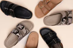 Sandalias marrones de cuero vacuno con doble tira y hebillas metálicas ajustables.