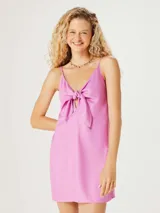 Vestido corto color rosa con breteles finos y lazo en el busto.